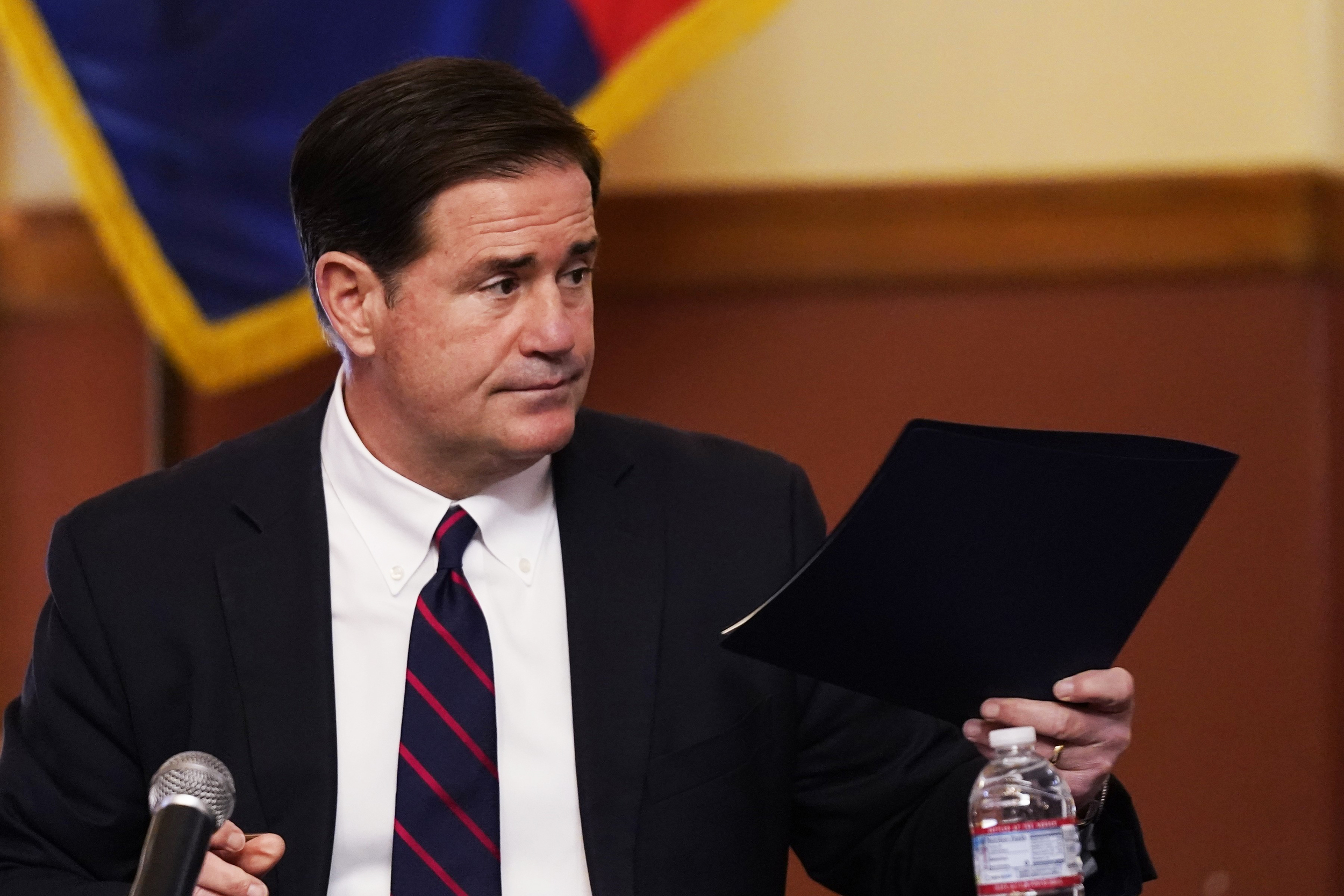 Arizona Gov. Doug Ducey hands over his signed election documents to certify the election results for federal, statewide, and legislative offices and statewide ballot measures at the official canvass at the Arizona Capitol, Monday, Nov. 30, 2020, in Phoenix. (AP Photo/Ross D. Franklin, Pool)